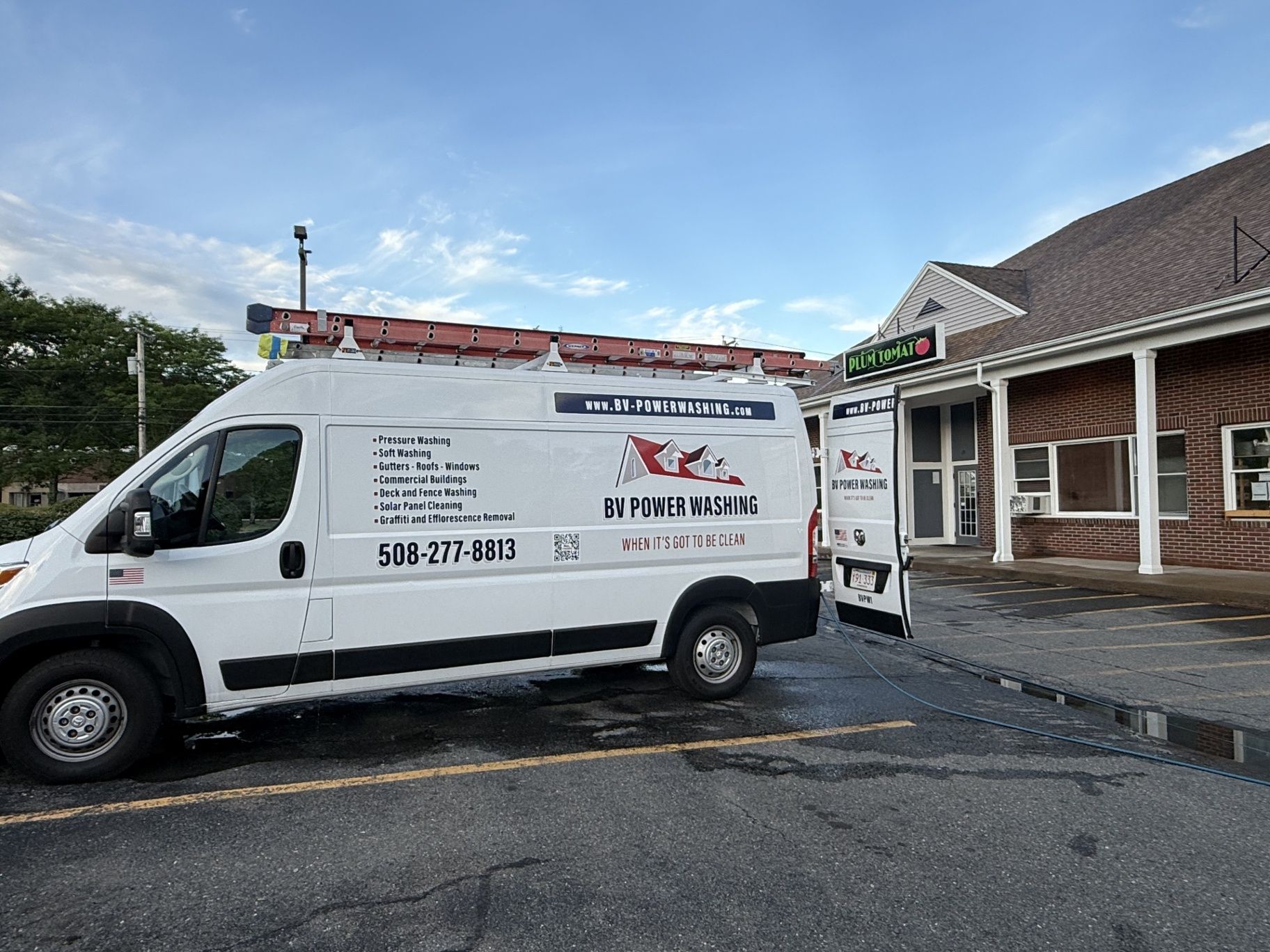 BV PowerWashing service van outside a commercial property in New England.